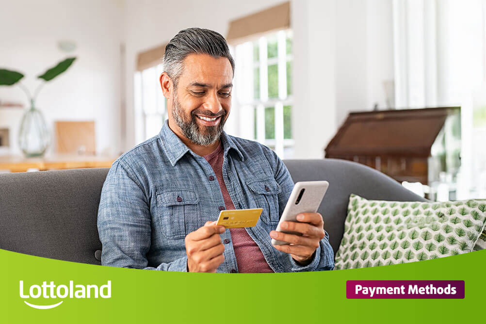 Happy man on mobile phone holding his credit card